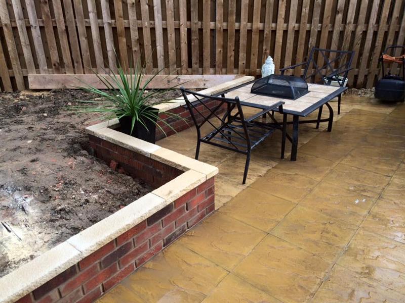 Raised brick planter and patio with garden furniture