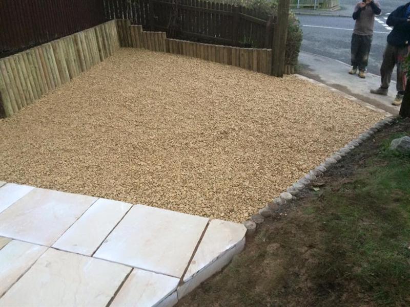 Gravelled area with timber sleeper edging and new paving